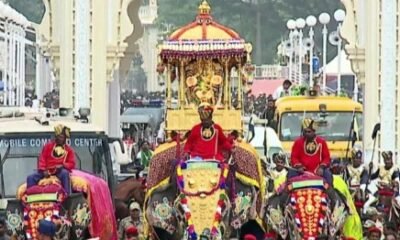 Golden howdah carrying Goddess Chamundeshwari during the Mysuru Dasara Jamboo Savari procession with decorated elephants and cultural tableaux.