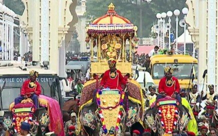 Golden howdah carrying Goddess Chamundeshwari during the Mysuru Dasara Jamboo Savari procession with decorated elephants and cultural tableaux.